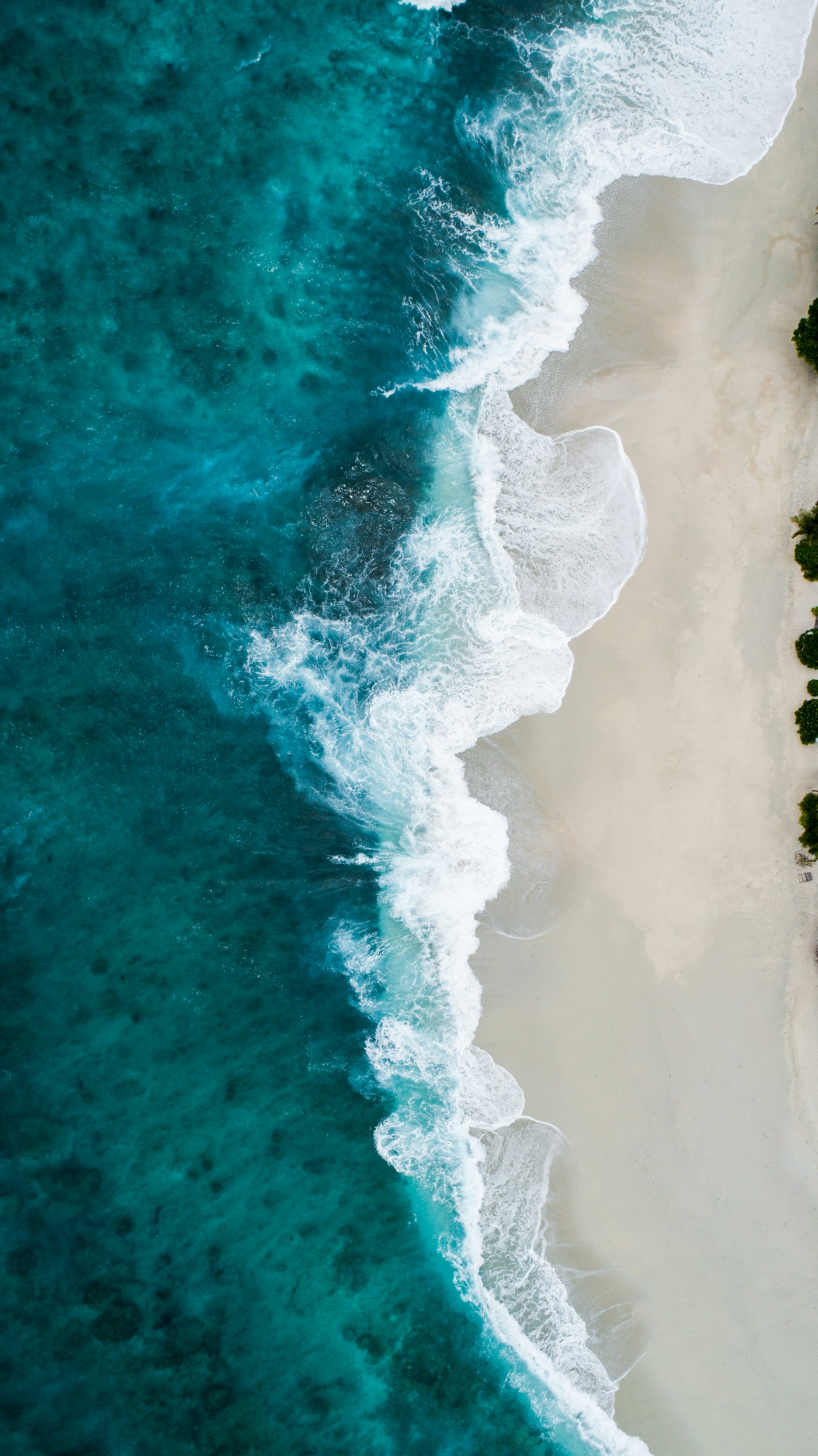 Whitewater meeting pale sand from above